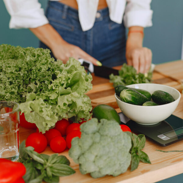 Beautiful girl make a salad. Sporty blonde in a kitchen