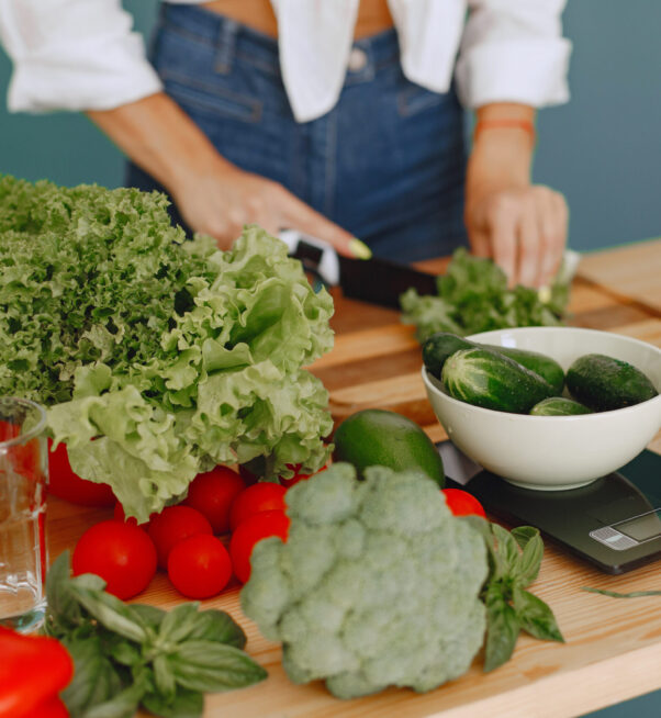 Beautiful girl make a salad. Sporty blonde in a kitchen