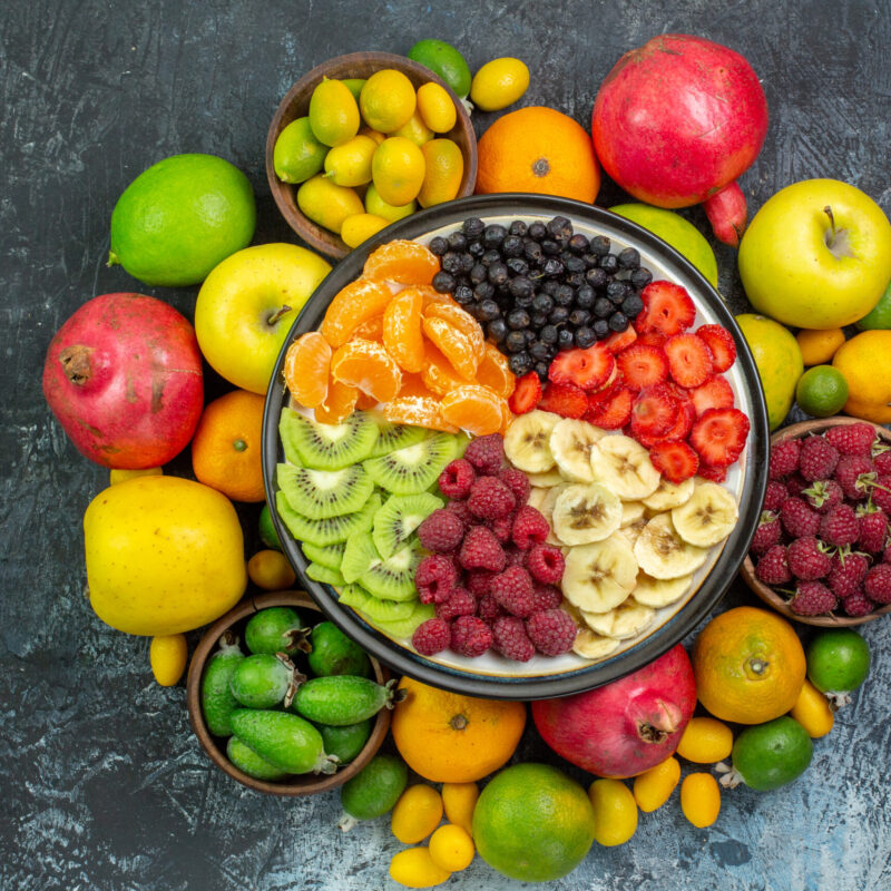 top-view-tasty-sliced-fruits-with-fresh-vegetables-gray-background