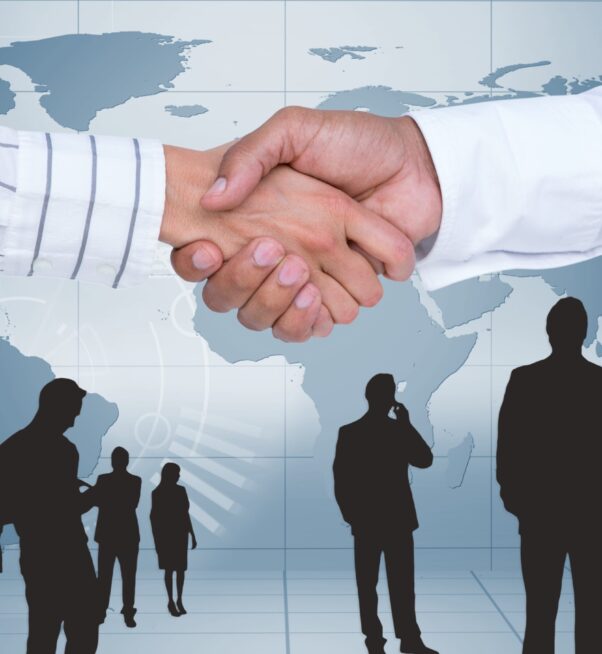 Digital composite image of businesspeople shaking hands against map background